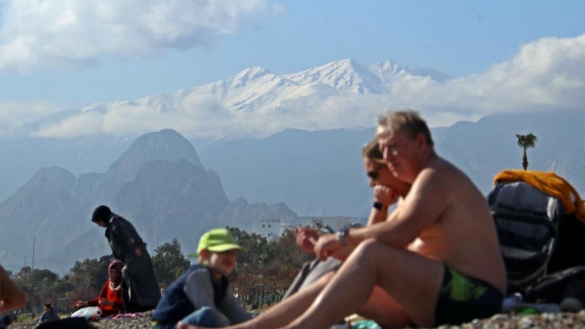 Antalya’da zirve beyaza bürünürken sahilde denize girdiler