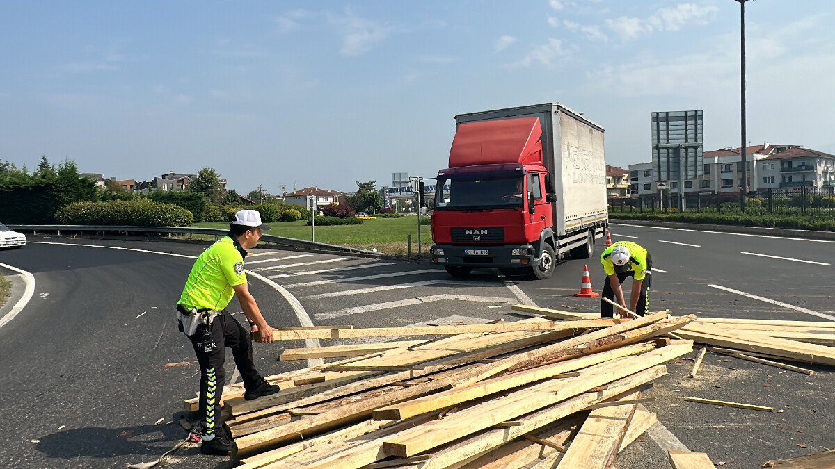 Düzce’de tır dorseninden dökülen keresteleri polisler taşıdı