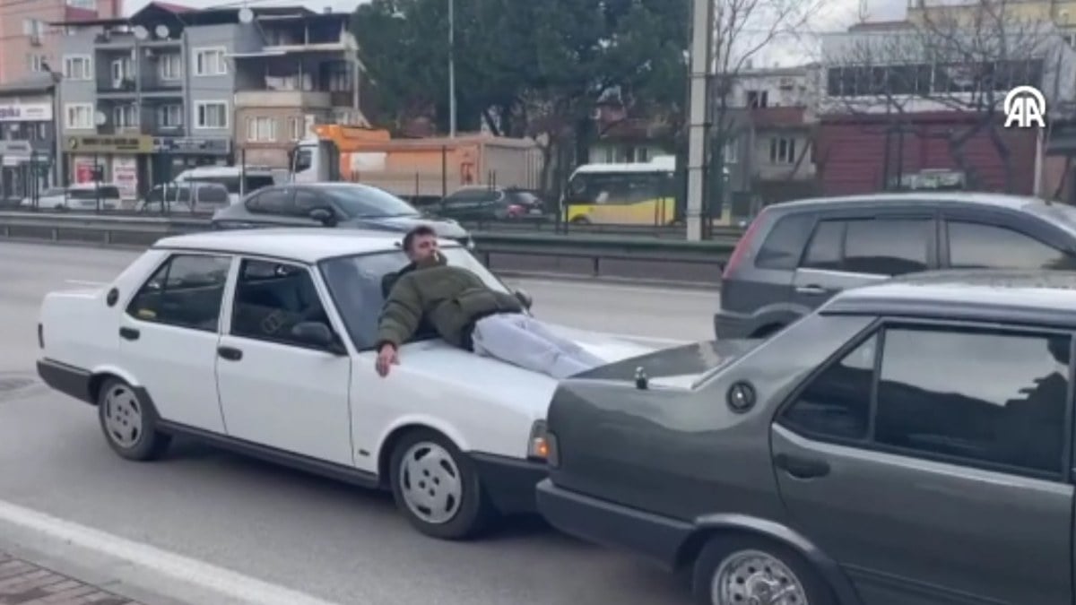 Bursa’da otomobilin kaputuna yatıp ayaklarıyla öndeki aracı itti
