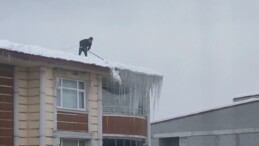 Bitlis’te beline ip bağlayan vatandaş, çatıda kar temizliği yaptı