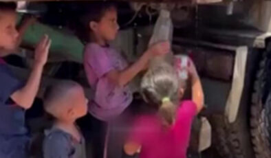 Gazzeli çocuklar kamyondan akan kirli suyu kaplara doldurmaya çalıştı