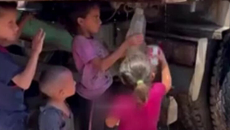 Gazzeli çocuklar kamyondan akan kirli suyu kaplara doldurmaya çalıştı